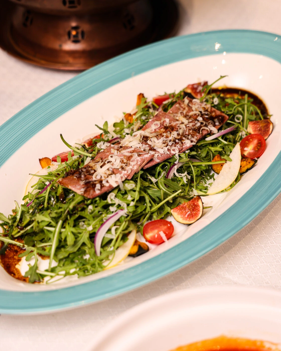 Sliced lamb with arugula, figs and tomato